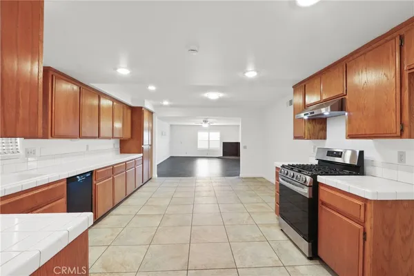 a large kitchen with stainless steel appliances granite countertop a stove a sink and a refrigerator