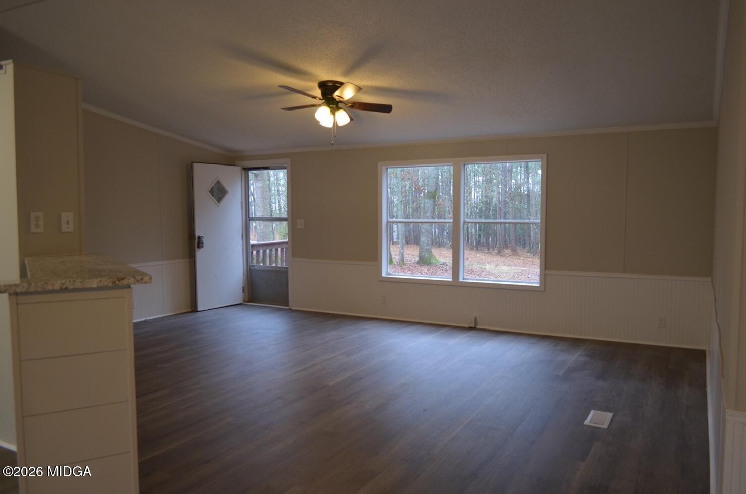 1048 Lee King Road Forsyth, GA 31029 - Photo 2 of 19 an empty room with wooden floor chandelier fan and windows