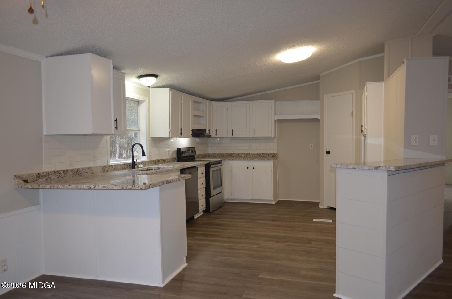1048 Lee King Road Forsyth, GA 31029 - Photo 4 of 19 a kitchen with stainless steel appliances granite countertop a sink stove and refrigerator