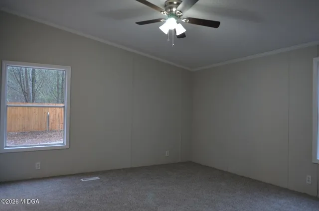 an empty room with a window and a fan