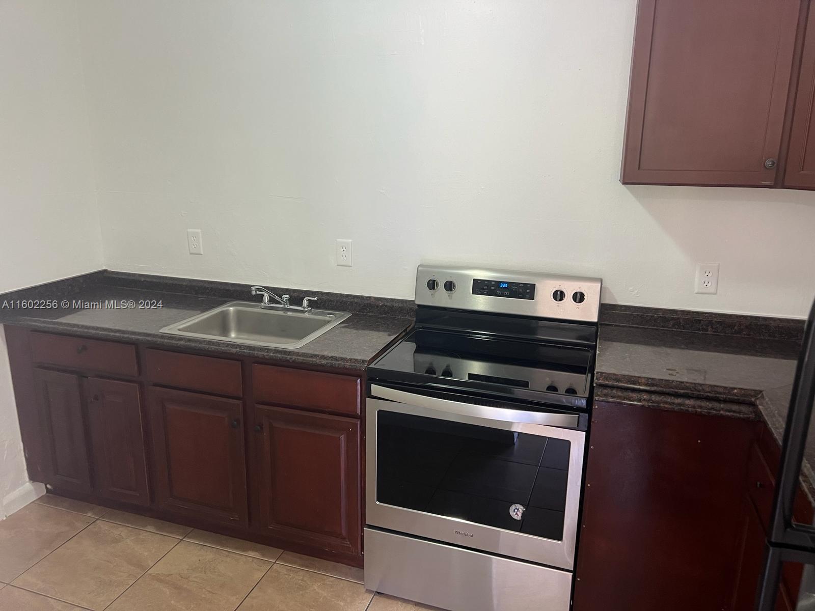 567 Northwest 90th Street, Unit 3 Miami, FL 33150 - Photo 4 of 11 a kitchen with granite countertop a stove and a sink