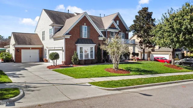 a view of a white house with a big yard and potted plants