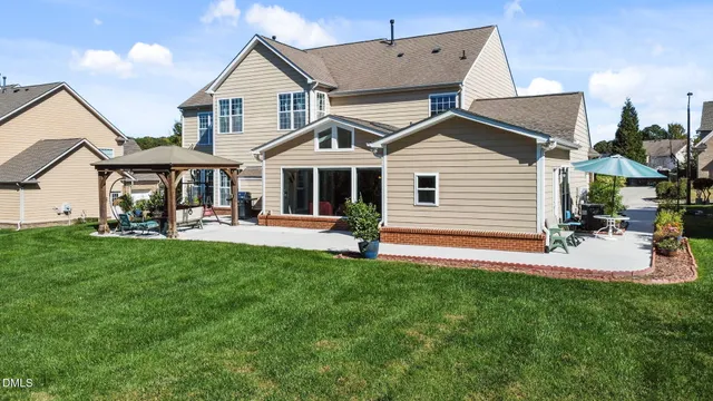 a view of a house with a yard and sitting area