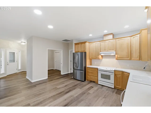 a kitchen with stainless steel appliances granite countertop a refrigerator and a stove top oven