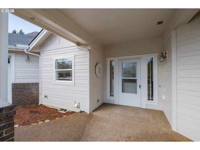 a view of an empty room with wooden floor and a ceiling fan