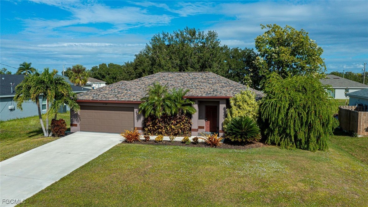 4108 13th Street Southwest Lehigh Acres, FL 33976 - Photo 1 of 48 a front view of a house with garden