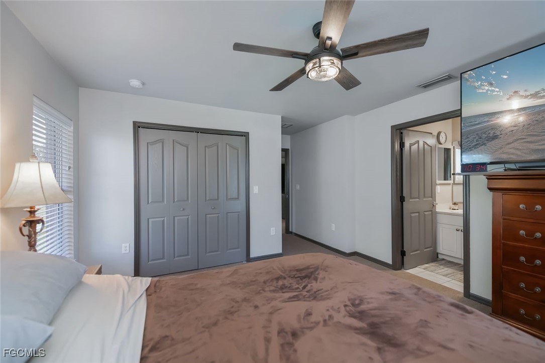 4108 13th Street Southwest Lehigh Acres, FL 33976 - Photo 15 of 48 a bedroom with a bed and a chandelier
