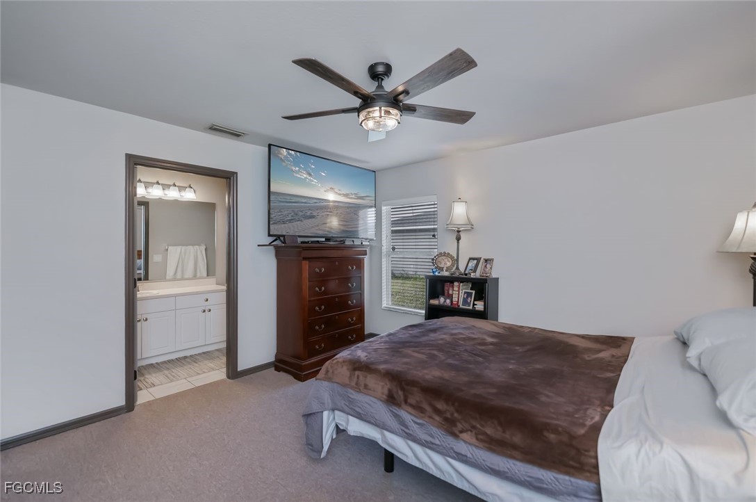 4108 13th Street Southwest Lehigh Acres, FL 33976 - Photo 16 of 48 a bed room with a bed and ceiling fan