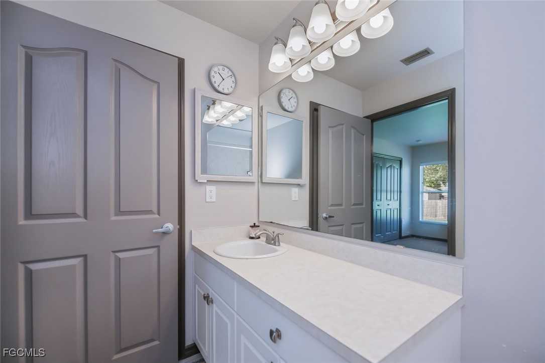 4108 13th Street Southwest Lehigh Acres, FL 33976 - Photo 22 of 48 a bathroom with a sink a light fixture and a mirror