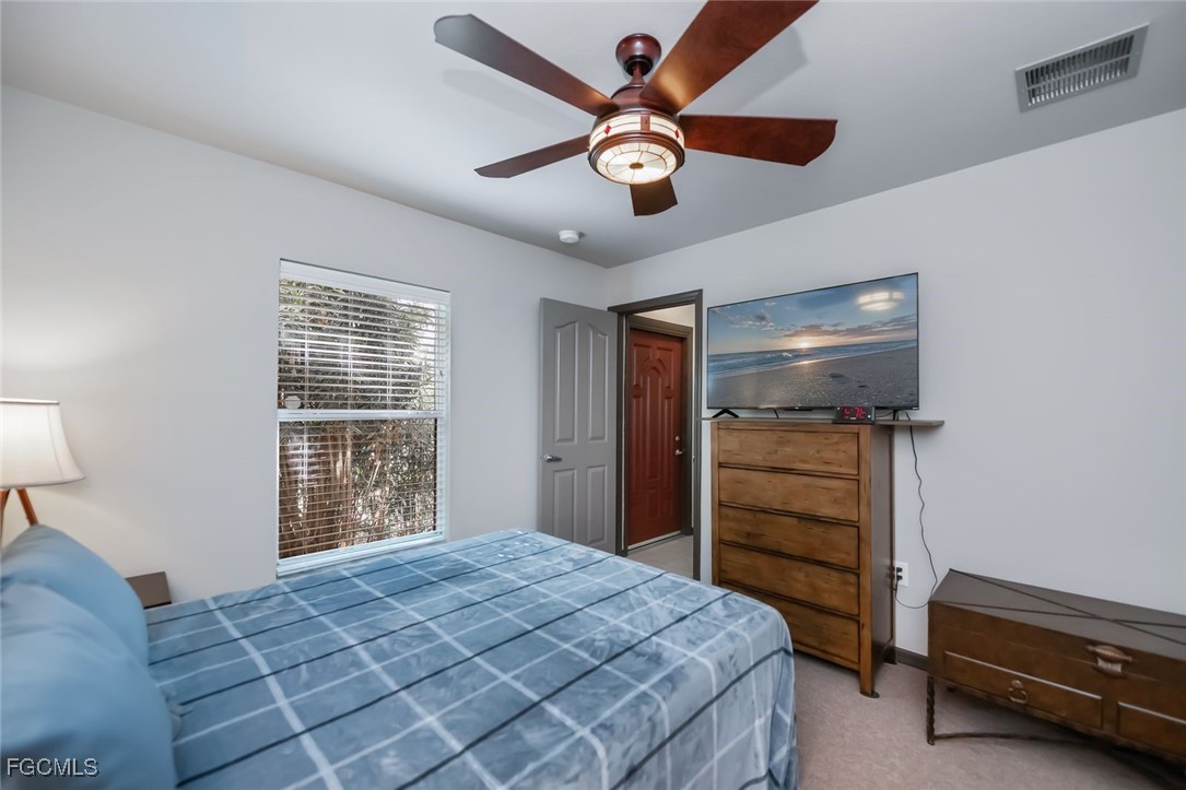 4108 13th Street Southwest Lehigh Acres, FL 33976 - Photo 28 of 48 a bedroom with a bed and a chandelier