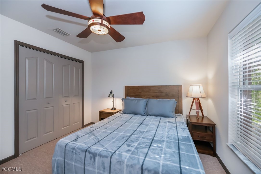 4108 13th Street Southwest Lehigh Acres, FL 33976 - Photo 29 of 48 a bedroom with a large bed and a chandelier