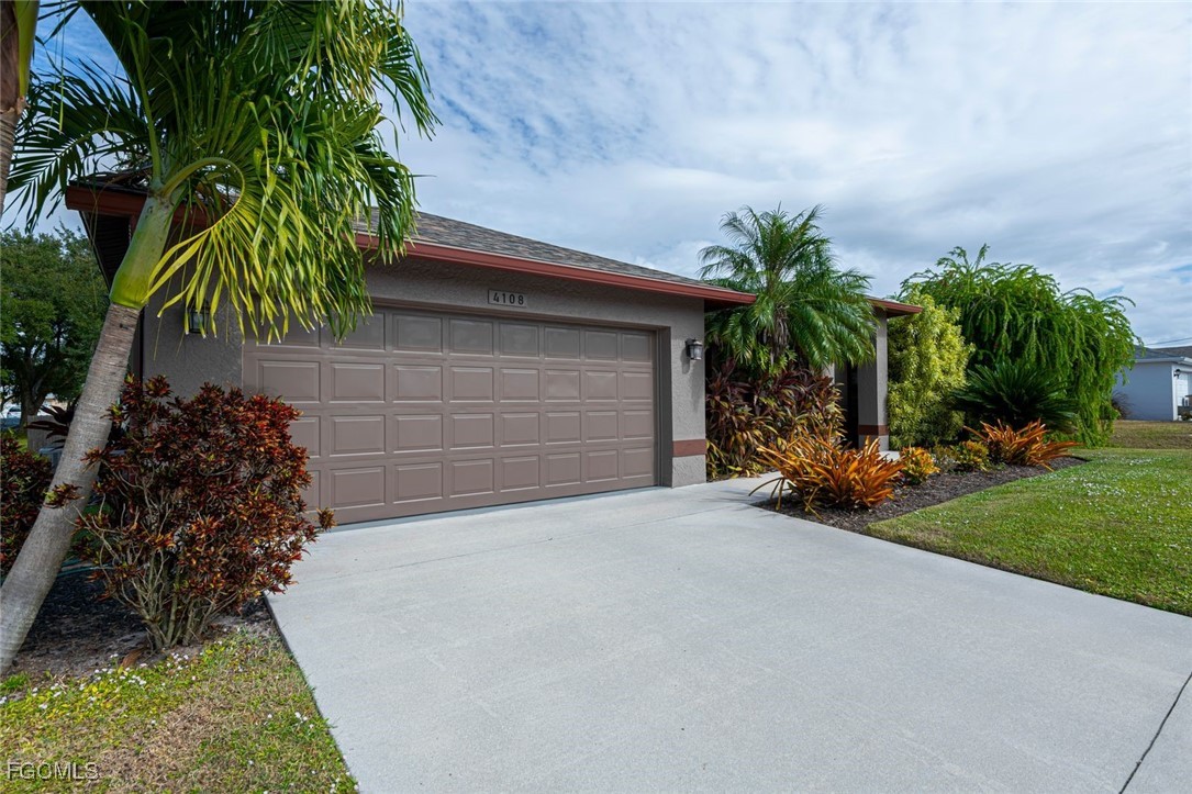 4108 13th Street Southwest Lehigh Acres, FL 33976 - Photo 36 of 48 a front view of a house with a yard and garage