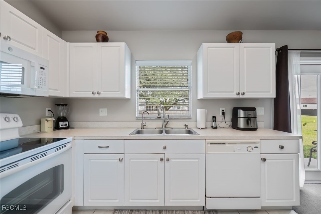 4108 13th Street Southwest Lehigh Acres, FL 33976 - Photo 7 of 48 a kitchen with granite countertop white cabinets and white appliances