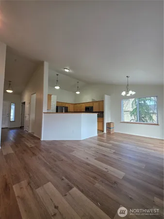 a view of empty room with wooden floor and fireplace
