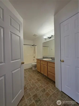 a bathroom with a granite countertop sink a toilet and shower