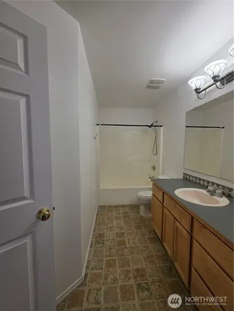a bathroom with a granite countertop sink a toilet and a mirror