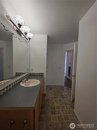 a bathroom with a granite countertop sink a mirror and shower