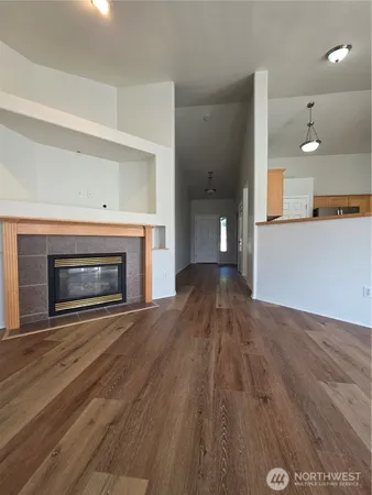 an empty room with wooden floor and a fireplace