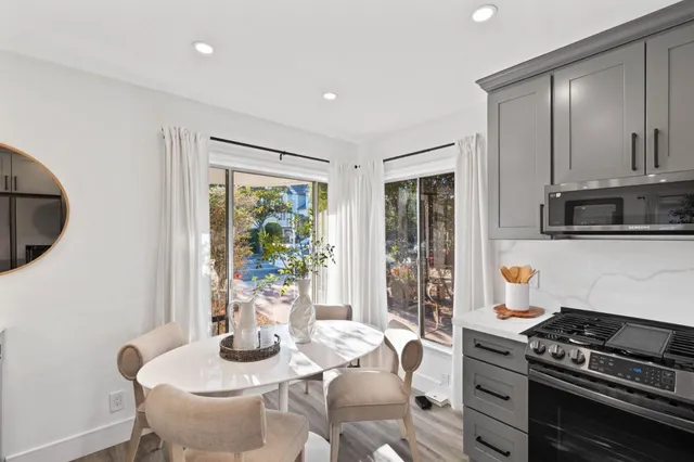 a kitchen with stainless steel appliances granite countertop a stove a sink and a dining table with garden view