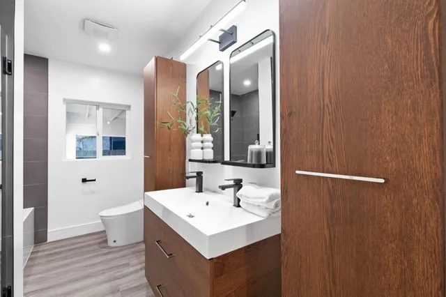 a bathroom with a sink mirror and a toilet