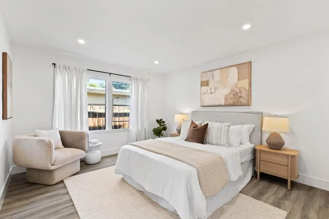 a bedroom with furniture and a large window