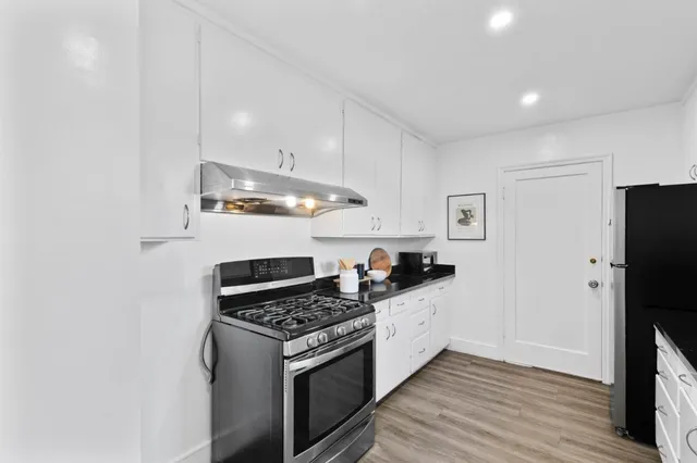 a kitchen with granite countertop a sink stove and refrigerator