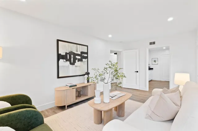 a living room with furniture and a painting on the wall