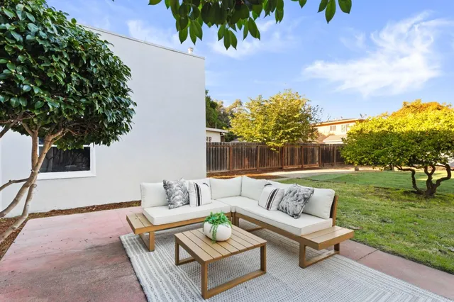 a backyard of a house with table and chairs