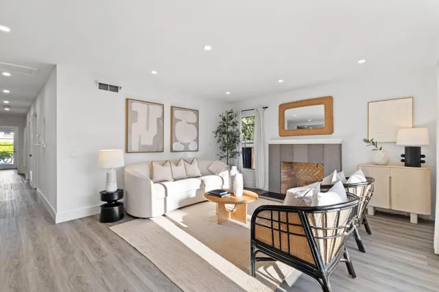 a living room with fireplace furniture and a wooden floor