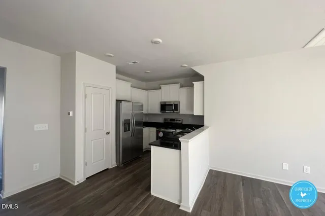 a kitchen with a refrigerator and a stove top oven