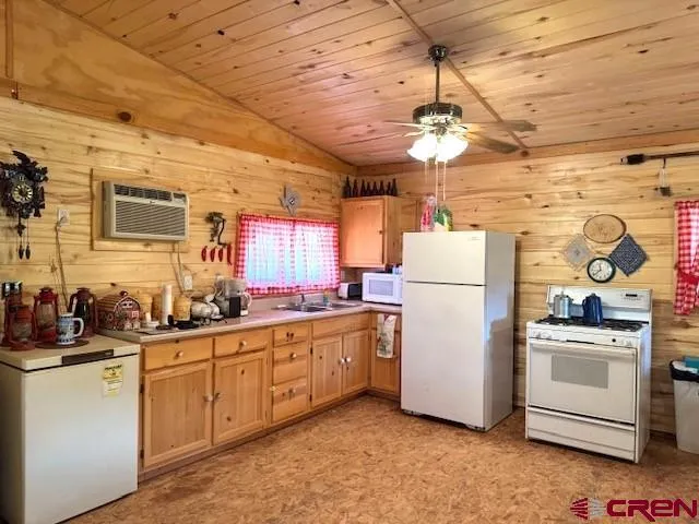 a kitchen with sink cabinets and white appliances