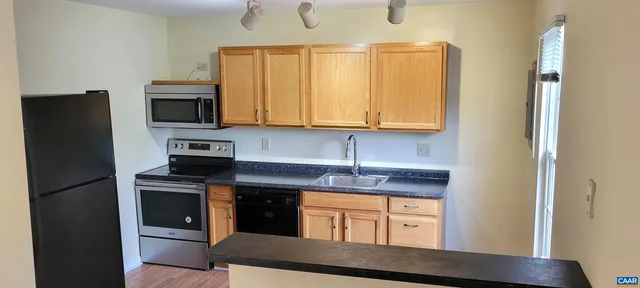 a kitchen with stainless steel appliances granite countertop a refrigerator microwave and sink