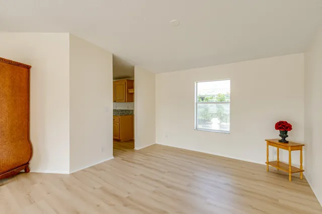 a large kitchen with granite countertop a large window a sink stainless steel appliances and cabinets