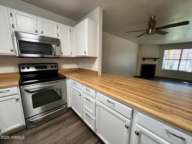 a kitchen with granite countertop a sink a stove and microwave