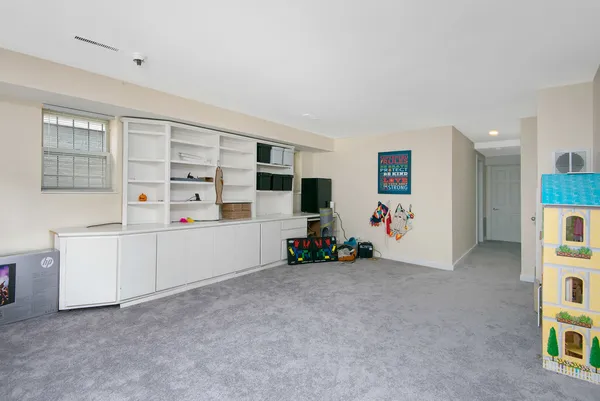a view of an empty room with cabinet and windows