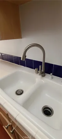 a kitchen with stainless steel appliances a stove a sink and a refrigerator with wooden floor