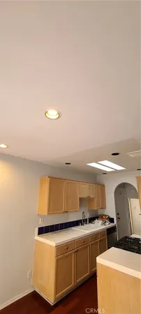 a view of a kitchen with a sink and dishwasher with a fireplace