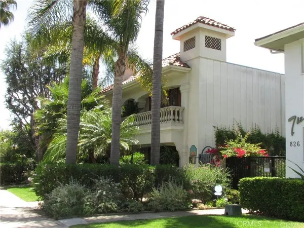 a front view of a house with a yard and potted plants
