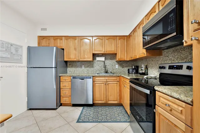 a kitchen with stainless steel appliances granite countertop a refrigerator sink and stove