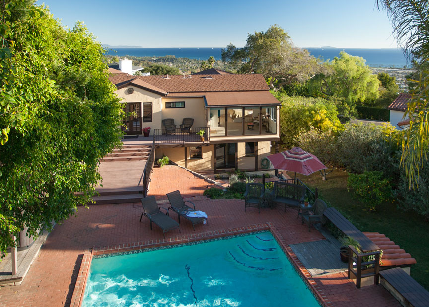 an aerial view of a house with swimming pool patio and outdoor seating