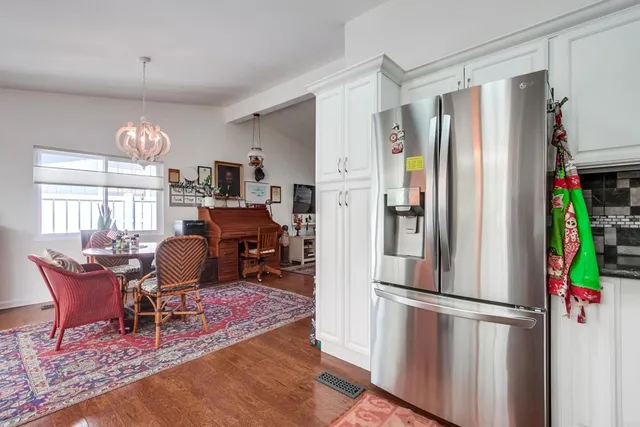 a kitchen with stainless steel appliances granite countertop a refrigerator and a dining table view