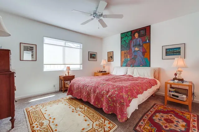 a bedroom with bed and paintings on the wall