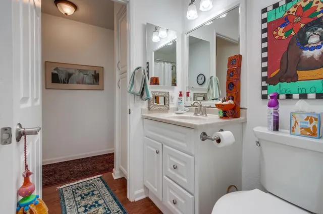 a bathroom with a sink mirror vanity and toilet