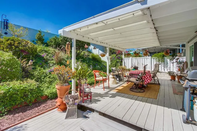 a view of a patio with lawn chairs and potted plants