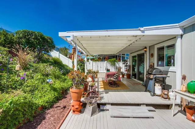 a view of a patio with table and chairs potted plants and floor to ceiling window