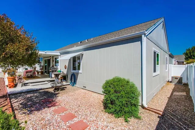a view of a house with backyard and sitting area