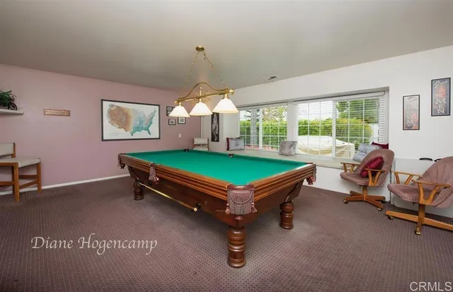 a room with pool table and windows