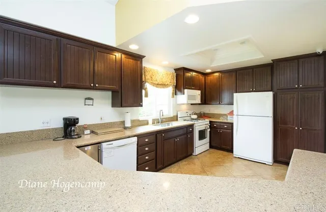 a kitchen with stainless steel appliances granite countertop a stove sink refrigerator and cabinets