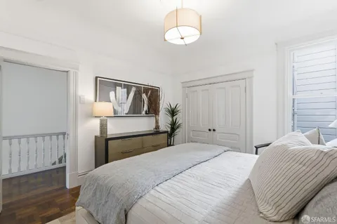 a bedroom with a large bed and a chandelier