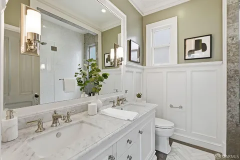 a en suite bathroom with a granite countertop sink and a mirror